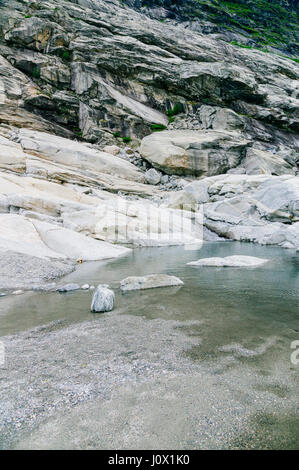 Stamm eines Berges mit rauen Felsen, Moräne und Schmelzwasser vom Gletscher Stockfoto