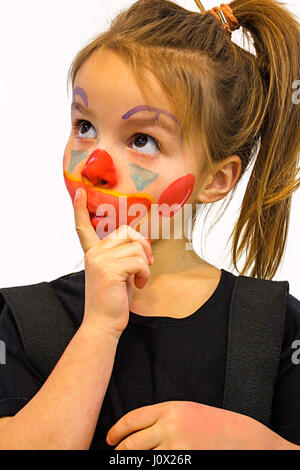 Mädchen mit Clown Gesicht malen und Finger auf ihre Lippen Stockfoto