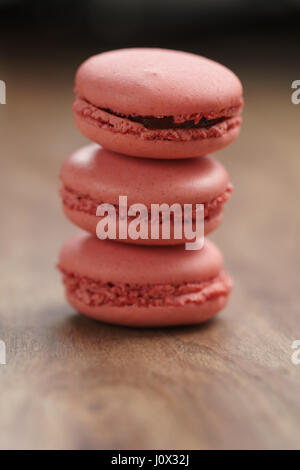 Closeup erschossen Stapel von pastellfarbenen Macarons mit Erdbeer-Geschmack auf Holztisch Stockfoto