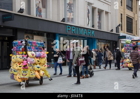 Primark auf Queen Street, Cardiff. Händler im Vordergrund sind Emoji Kissen etc. verkaufen. Stockfoto