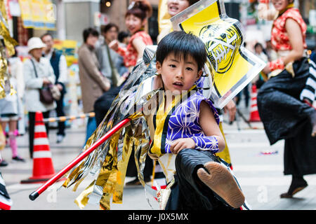 Japan, Kumamoto, Hinokuni Yosakoi Dance Festival. Kind, Junge, 7-8 Jahre alt tanzen und winken Standard um, treten in Richtung Betrachter. Bis zu schließen. Stockfoto