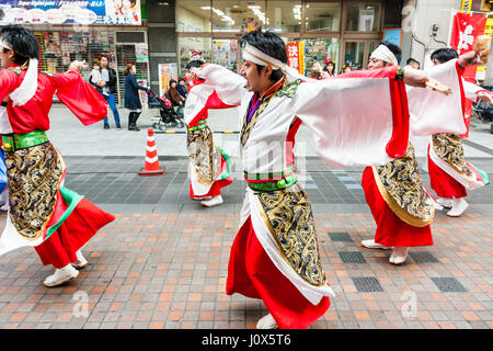 Hinokuni Yosakoi Dance Festival. Mannschaft gekleidet in den Farben weiß und rot, Yukata, ihre langen Ärmel um wirbelnden beim Tanzen in der Shopping Mall. Stockfoto