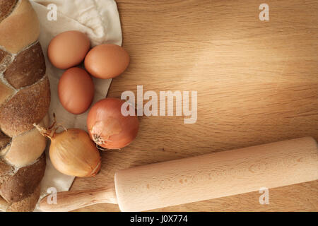 geflochtene Brot mit Zwiebeln, Eiern und Nudelholz auf einem Holztisch mit Textfreiraum, Food-Konzept Stockfoto