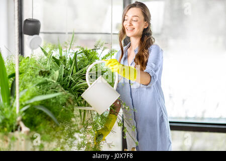 Junge Gärtner in der Orangerie mit Grünpflanzen Stockfoto