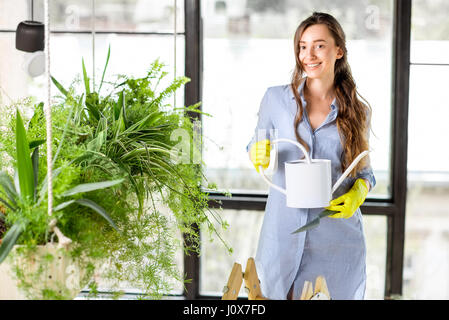 Junge Gärtner in der Orangerie mit Grünpflanzen Stockfoto