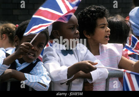 Einheimische Kinder winken Union Jack-Flaggen für Prinz Charles Besuch in Handsworth, Birmingham Uk Juni 1986 Stockfoto