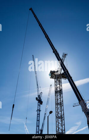 Kran jibs und teilweise errichteten Turm Kran auf eine neue Entwicklung vor Ort in der Nähe von Cutting Room Square, Ancoats, Manchester, England, UK Stockfoto