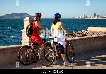 Ein paar auf Fahrräder stoppen, um den Blick über die Strandpromenade in Mazatlan, Sinaloa, Mexiko genießen. Stockfoto