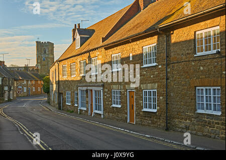 Straßenszene in kleinen Dorset Dorf von Abbotsbury mit der Straße in Richtung der kleinen Kirche des Heiligen Nikolaus. Stockfoto