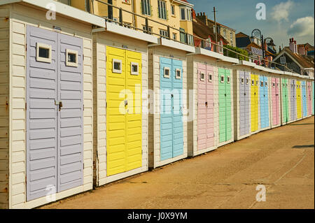 Eine Reihe von bunten Strandhäuschen direkt am Meer bei Lyme Regis in Dorset. Stockfoto