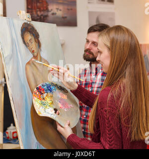 Master-Klasse in der Kunstschule. Das Mädchen zeichnet ein Porträt mit Ölfarben und die Lehrer-Kommentare über die Arbeit in den Prozess der Ausführung. Kurse von Dr. Stockfoto