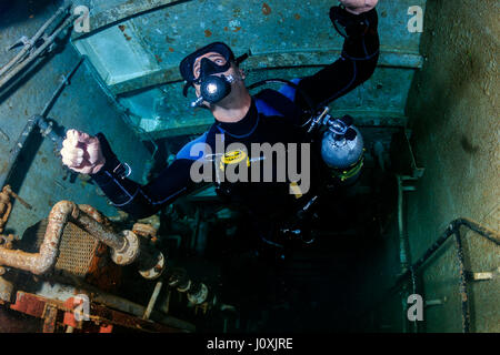 Taucher in Sidemount-Konfiguration tief im Inneren ein Unterwasser Schiffbruch Stockfoto