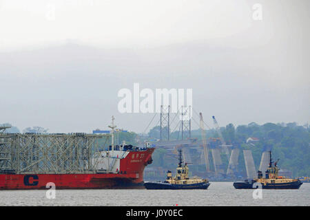 Das Schiff der ersten Mammut Sendung aus Stahl für die neue Forth Road Bridge (die Queensferry Crossing, Zeit für die Fertigstellung im Jahr 2016) bahnt sich ihren Weg vorbei an laufenden Arbeiten an der südlichen landfall Stockfoto