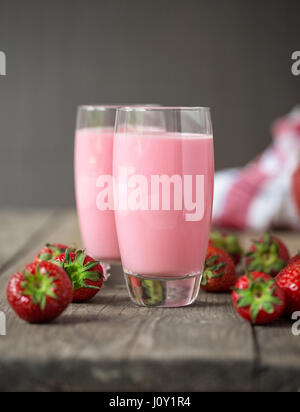 Frische kalte Erdbeer-Smoothies mit frischen Früchten auf hölzernen Hintergrund Stockfoto