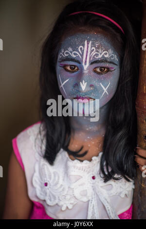 Indisches Mädchen nachdem er ihr Gesicht gemalt auf dem Gajan und Charak Festival in Krishnadepur, West-Bengalen Stockfoto