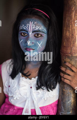 Indisches Mädchen nachdem er ihr Gesicht gemalt auf dem Gajan und Charak Festival in Krishnadepur, West-Bengalen Stockfoto