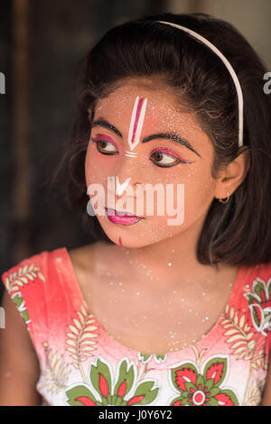 Indisches Mädchen nachdem er ihr Gesicht gemalt auf dem Gajan und Charak Festival in Krishnadepur, West-Bengalen Stockfoto