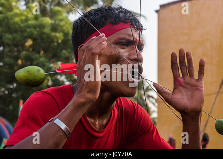 Indischen Jüngling mit Spießen über seine Wangen beim Gajan und Charak-Festival in Krishnadepur, West-Bengalen Stockfoto