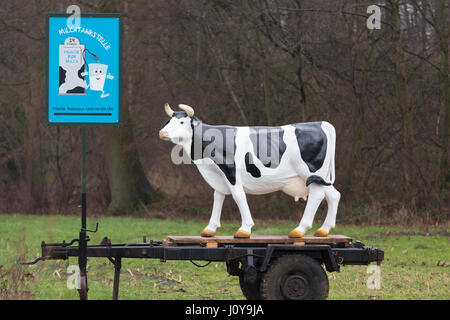 Modell-Kuh, die Milch in der Nähe von Milchviehbetrieb in Deutschland Werbung Stockfoto