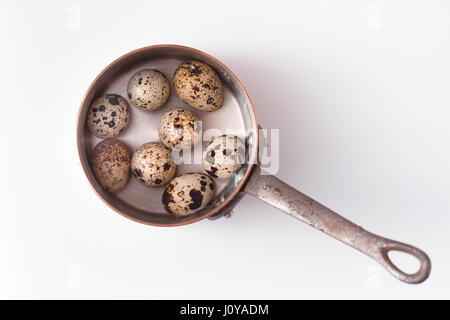 Wachteleier in einem alten Topf. Auf einem weißen Hintergrund horizontale Stockfoto