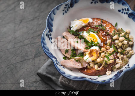 Salat mit Huhn, Kürbis, Bohnen und Wachteleier in einer Keramikschale horizontalen Stockfoto