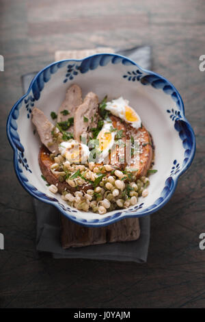 Salat mit Huhn, Kürbis, Bohnen und Wachteleier in einer Schüssel Draufsicht vertikalen Stockfoto