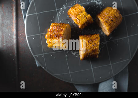 Scheiben von geröstetem Mais Keramikplatte oben horizontal anzeigen Stockfoto