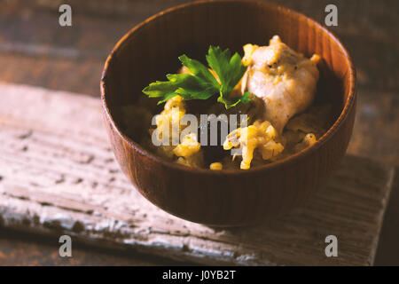 Pilaf mit Reis und Huhn Rosinen in waagerechter Holzschale Seite Ansicht Stockfoto