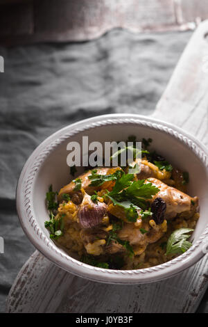 Pilaf mit Reis und Huhn, Rosinen in einer Keramikschale vertikalen Stockfoto
