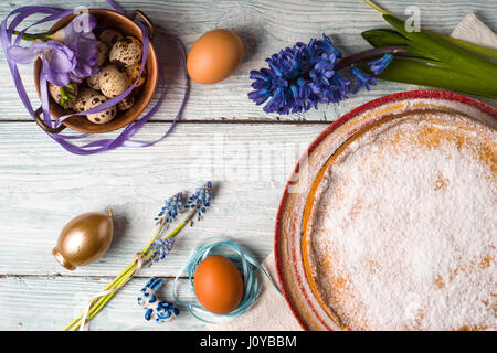 Deutsch Osterkuchen mit Dekoration und Blumen auf der weißen hölzernen Tischplatte-Ansicht Stockfoto