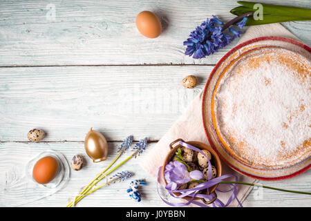 Deutsch Osterkuchen mit Dekoration und Blumen auf dem weißen Holztisch Stockfoto