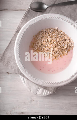 Fruchtjoghurt mit Eiche Flocken auf der weißen hölzernen Tischplatte-Ansicht Stockfoto