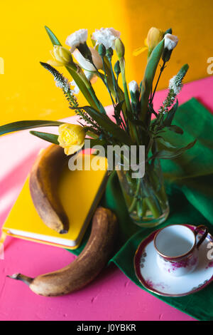 Strauß Tulpen und Nelken auf einem rosa Tisch Stockfoto