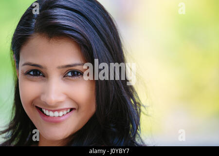 Closeup Kopfschuss Porträt zuversichtlich isoliert Lächeln gerne hübsche junge Frau, Hintergrund unscharf Bäume. Positive menschliche Emotion Gesichts expressio Stockfoto