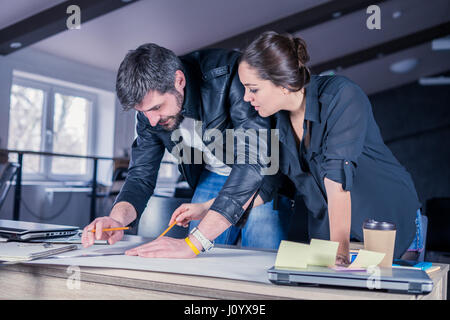 Architekten-Leute diskutieren Bauprojekt auf Schreibtisch. Stockfoto