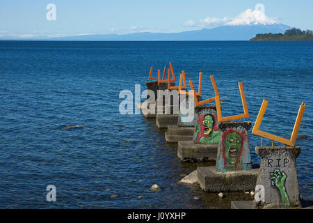 Wandmalereien, einen verlassenen Pier am Llanquihue-See in Puerto Varas, Südchile zu verzieren. Schneebedeckte Vulkan Osorno (2.652 m) in der Ferne. Stockfoto