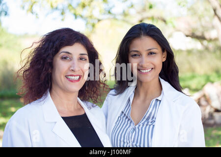 Closeup Portrait freundlich, lächelnd zuversichtliche Ärztinnen, medizinisches Fachpersonal mit Laborkittel, isoliert im freien außerhalb Background. Patient ho Stockfoto