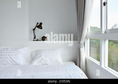 moderne Lampe auf hölzerne Nachttisch in weißen modernen Schlafzimmer, Innenarchitektur Stockfoto