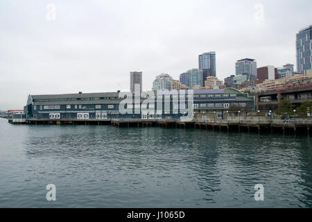 SEATTLE, WASHINGTON, USA - 25. Januar 2017: Ein Blick auf Seattle downtown aus den Gewässern des Puget Sound. Piers, Wolkenkratzer, Seattle Aquarium in der Stadt vor Sonnenuntergang Stockfoto