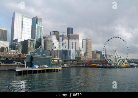 SEATTLE, WASHINGTON, USA - 25. Januar 2017: Ein Blick auf Seattle downtown aus den Gewässern des Puget Sound. Piers, Wolkenkratzer und Riesenrad in Seattle Stadt vor Sonnenuntergang Stockfoto