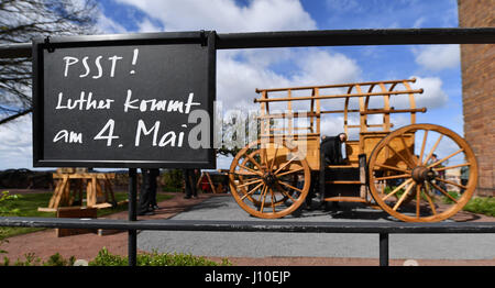 Eisenach, Deutschland. 11. April 2017. Ein Schild steht "Psst! Luther Kommt am 4. Mai "(lit.) Psst! Luther kommt am 4. Mai) als eine originalgetreue Nachbildung des "Luthers Reisewagen" (lit.) Luthers Reise Wagen) wird von Arbeitern auf der Wartburg in Eisenach, Deutschland, 11. April 2017 eingerichtet. Der 4,2 Meter lange und 2,6 Meter hohe Wagen soll um die nationalen Sonderausstellung zu fördern "Luther Und die Deutschen" (lit.) Luther und die deutschen) voraussichtlich am 04 Mai eröffnet. Foto: Martin Schutt/Dpa-Zentralbild/Dpa/Alamy Live News Stockfoto