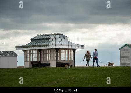 Menschen zu Fuß entlang der Promenade an einem bewölkten und bewölkten Tag Hunde. Stockfoto