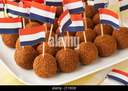 Niederländische traditionelle Snack Bitterballen auf einen Teller mit einem Cocktailspieß niederländische Flagge Stockfoto