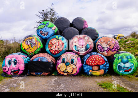 Haybales gestapelt an der Seite einer Straße mit verschiedenen bunten Flächen und Objekte auf ihnen gemalt werden. Stockfoto