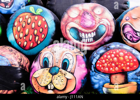 Haybales gestapelt an der Seite einer Straße mit verschiedenen bunten Flächen und Objekte auf ihnen gemalt werden. Stockfoto