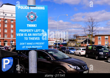 Schild am ein Parkplatz zur Verfügung gestellt von der Polizei "Police Warnung. Denke! Eigenschaft im Blick nach links ist eine Einladung für Diebe. Machen Sie kein Geschenk Ihres Eigentums. Stockfoto