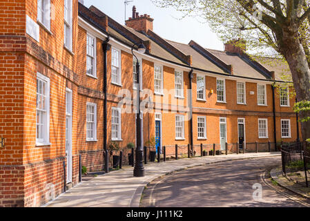 Klassische britische Halbmond mit restaurierten viktorianischen roten Ziegeln Häuser auf einer Ortsstraße mit kleinen Garten vor Stockfoto