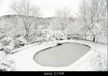 Hinterhof-Pool im Winter, nach schweren Schneefall, Sturm, bedeckt mit Schnee und Eis, London, Ontario, Kanada. Stockfoto