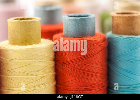 Rollen oder Spulen von bunten Nähfäden. Gewinde in allen Farben. Geringe Schärfentiefe. Nahaufnahme Makro erschossen. Stockfoto
