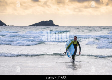 Surfen-UK; Surfer; Fistral; Cornwall; Fuß aus dem Meer; Surfbrett tragen; Meer; Watersport; Am Abend; Müde; Freizeitbeschäftigung; Lebensstil Stockfoto